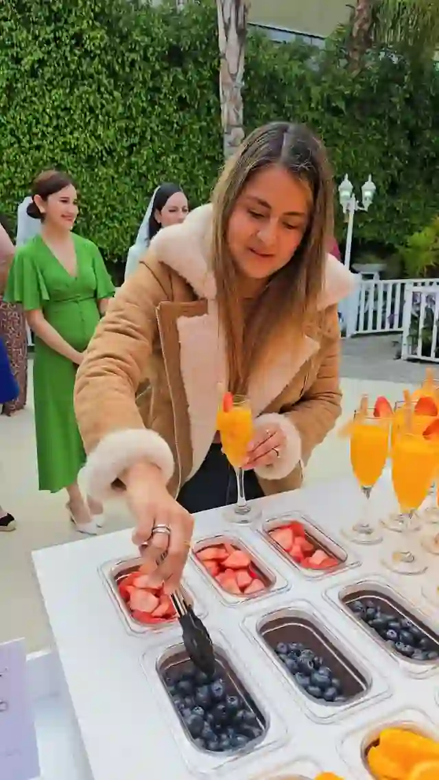 Invitadas sirviéndose fruta y mimosas en una barra de Bonne Lune
