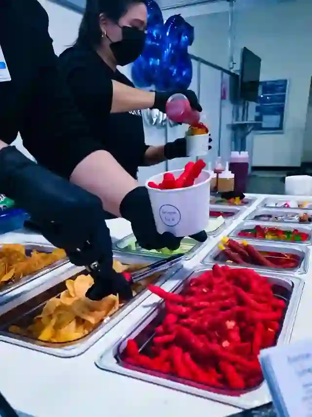 Preparación de un vaso de snacks con chile y botana en un evento