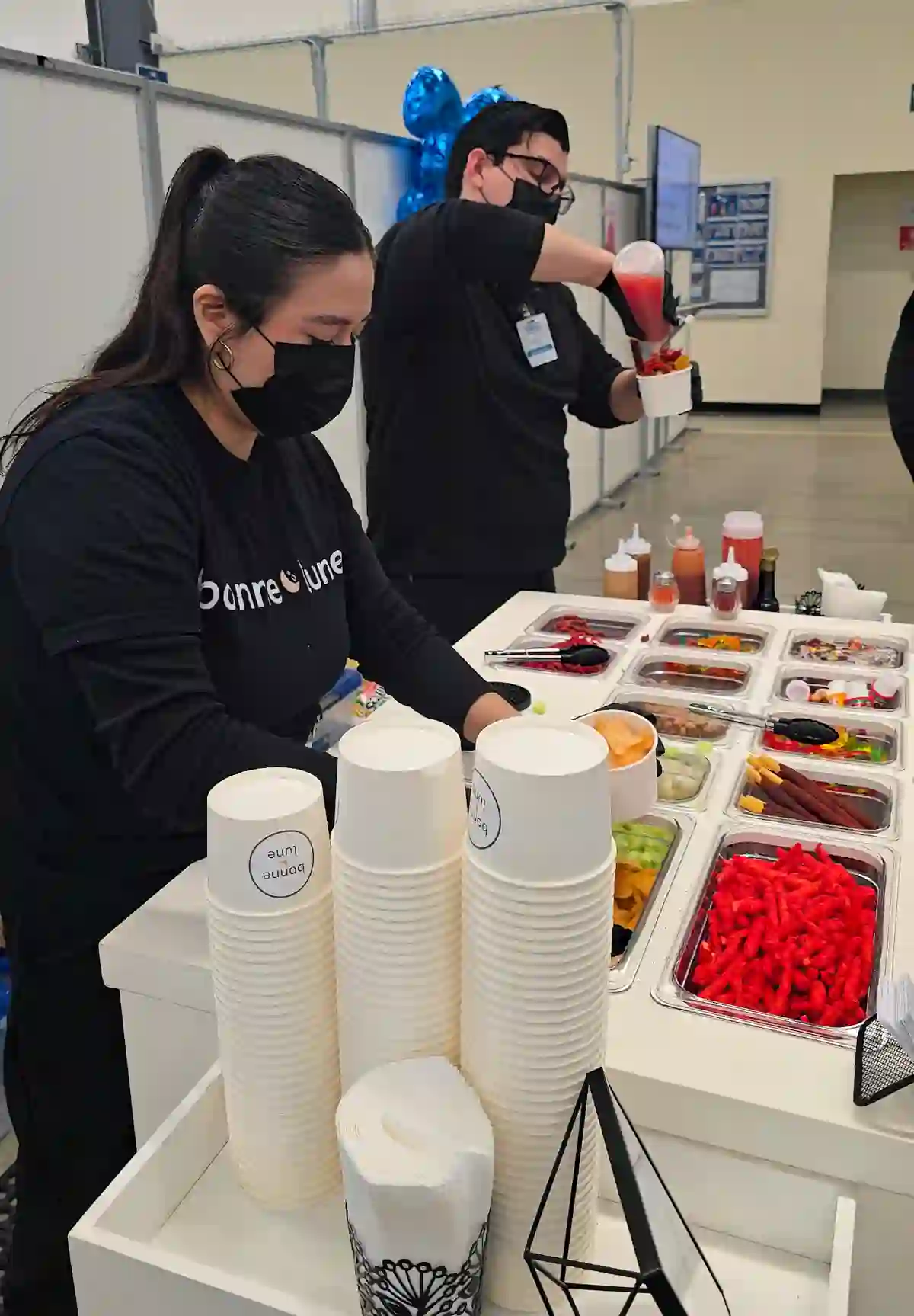 Equipo de Bonne Lune, con playeras de la marca, preparando una barra de snacks