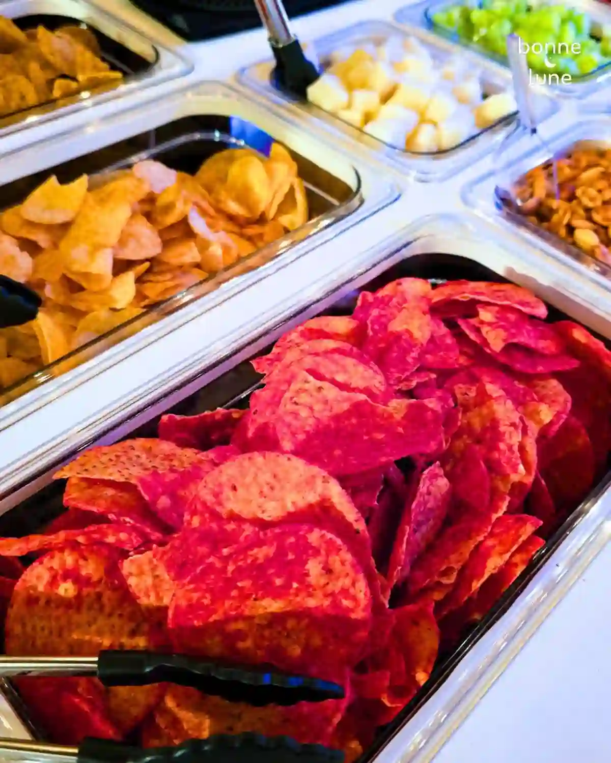 Charolas de papas y botana variada en la barra de snacks de Bonne Lune